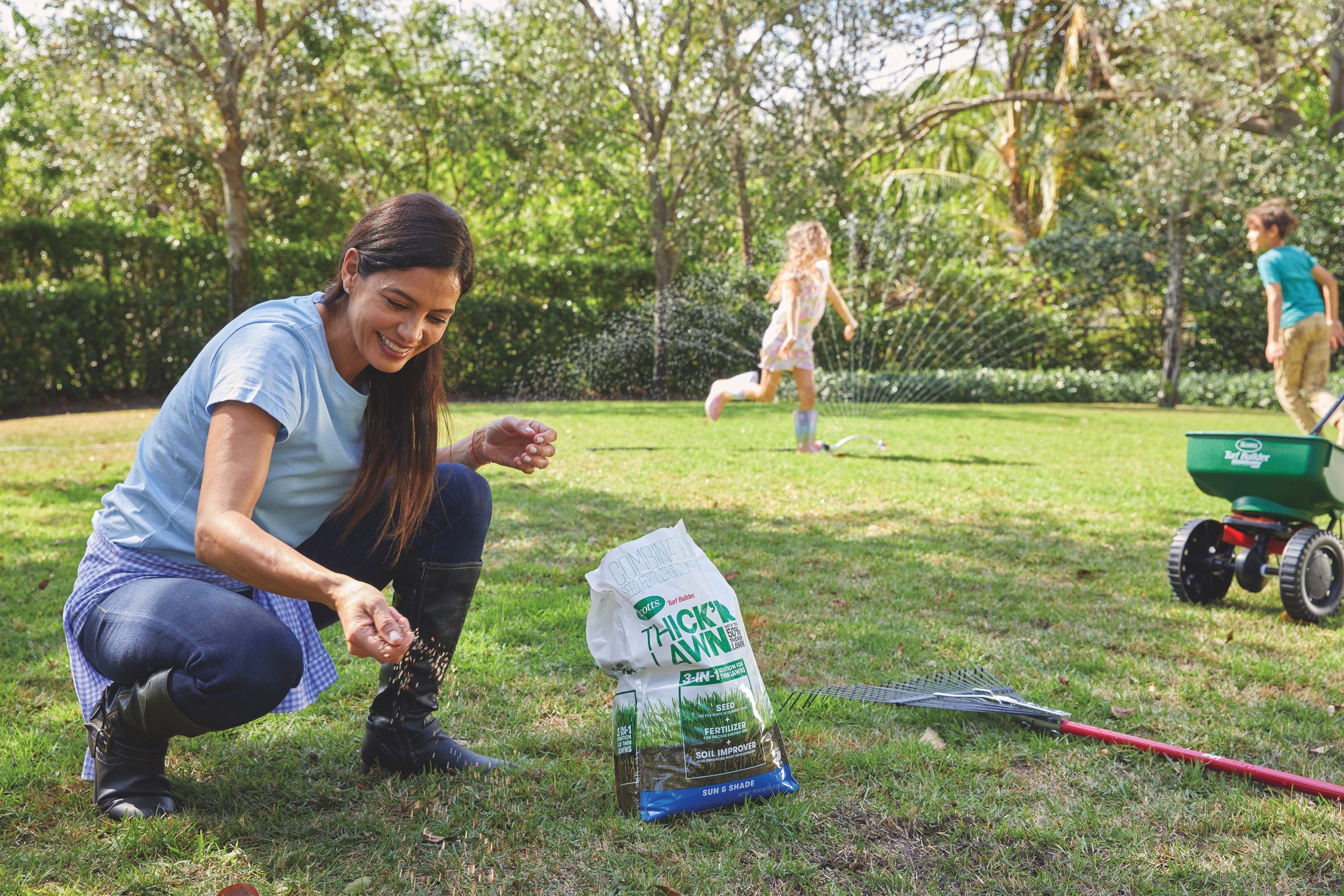 Woman spreading seed on her lawn.