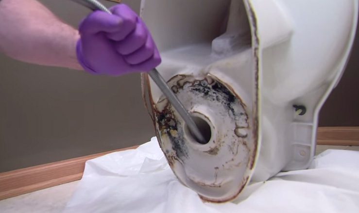 Run auger from bottom of toilet